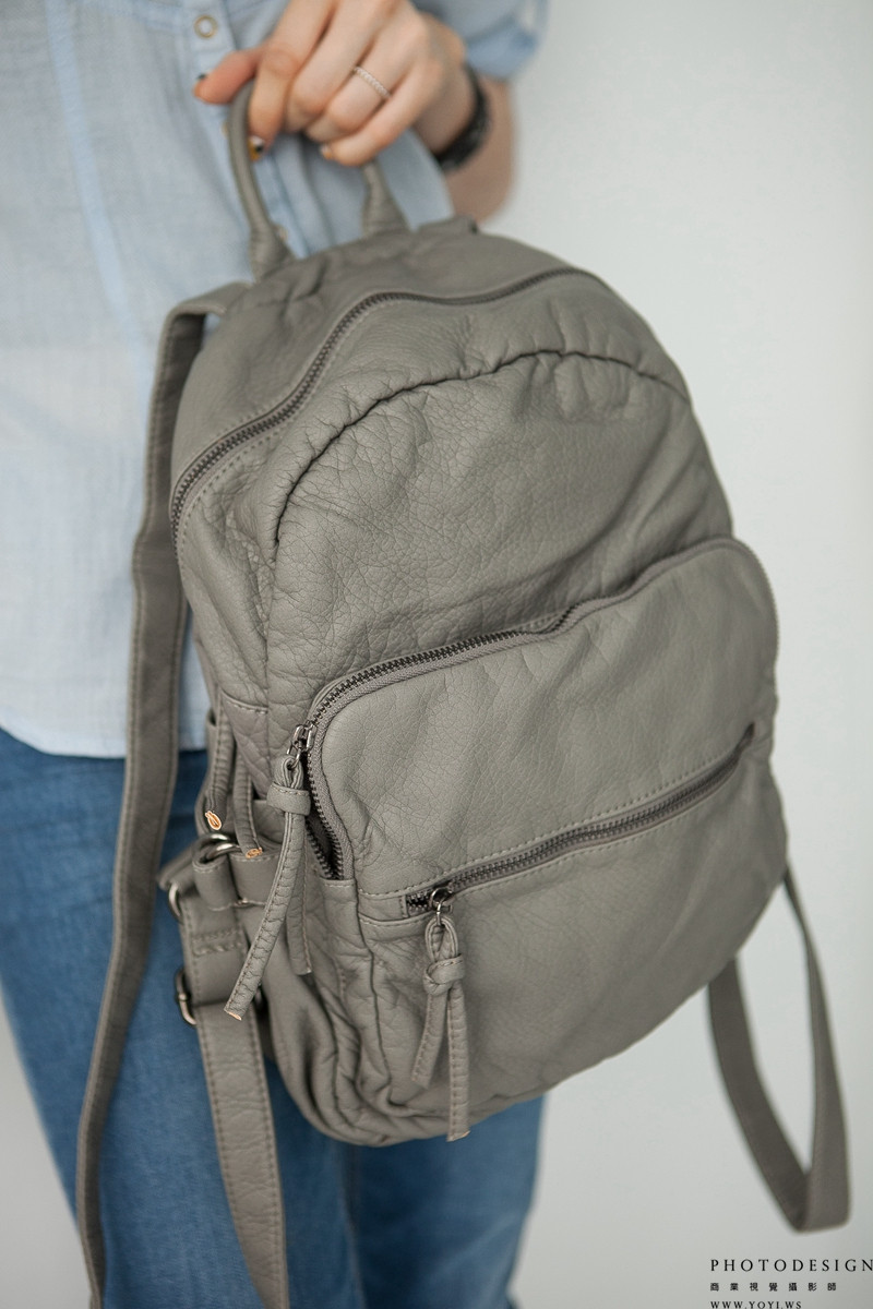 真皮側背包的皮革紋理與縫線工藝特寫，高解析度產品圖