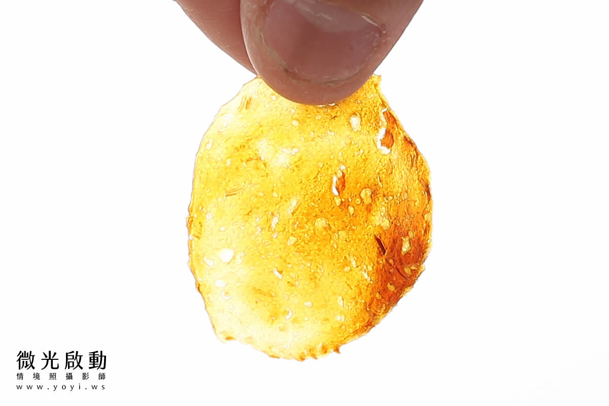 一隻黑白吉娃娃正開心地吃著主人手餵的寵物零食，表情非常滿足。