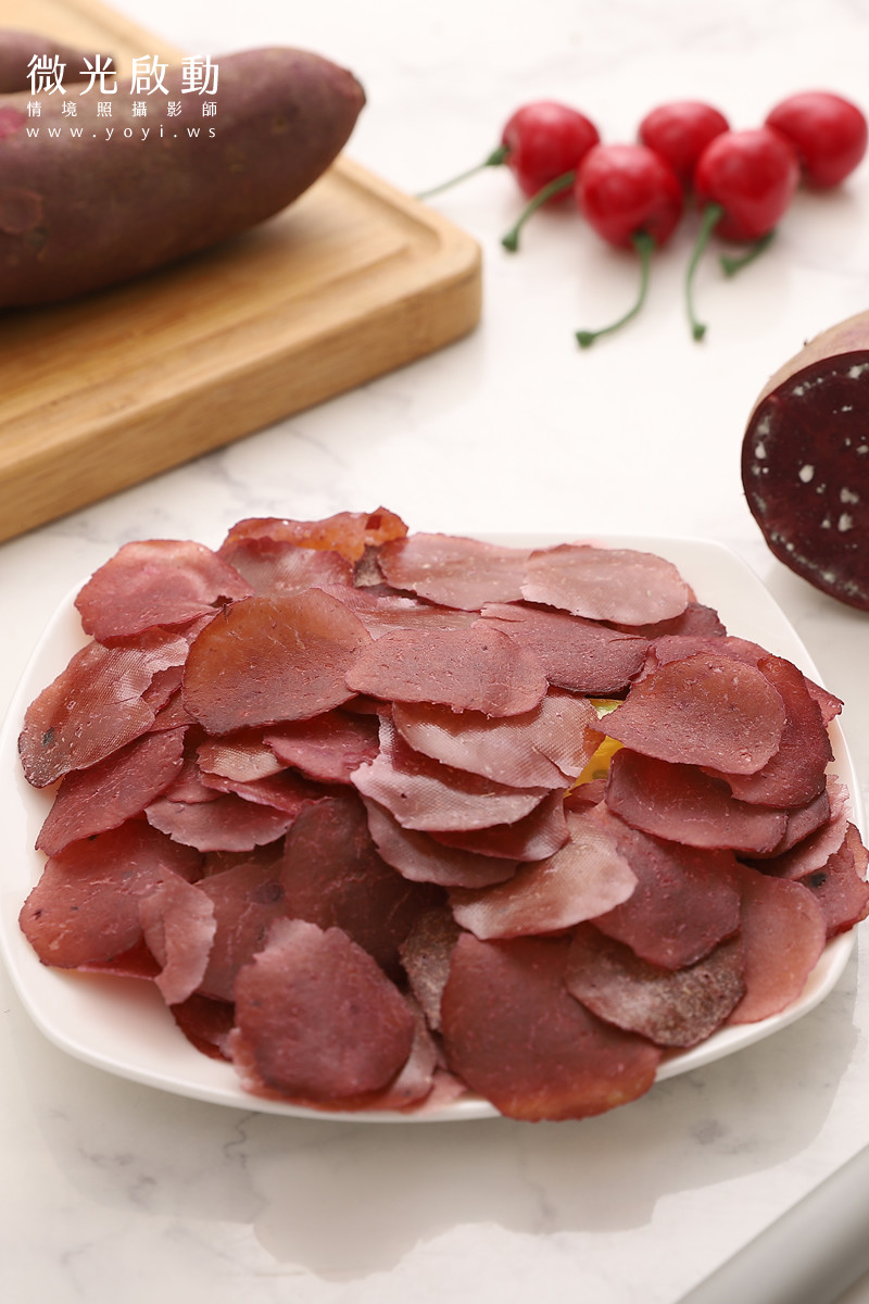 一隻活潑可愛的吉娃娃犬坐在地上，身後有兩罐透明罐裝寵物零食，表情充滿期待。