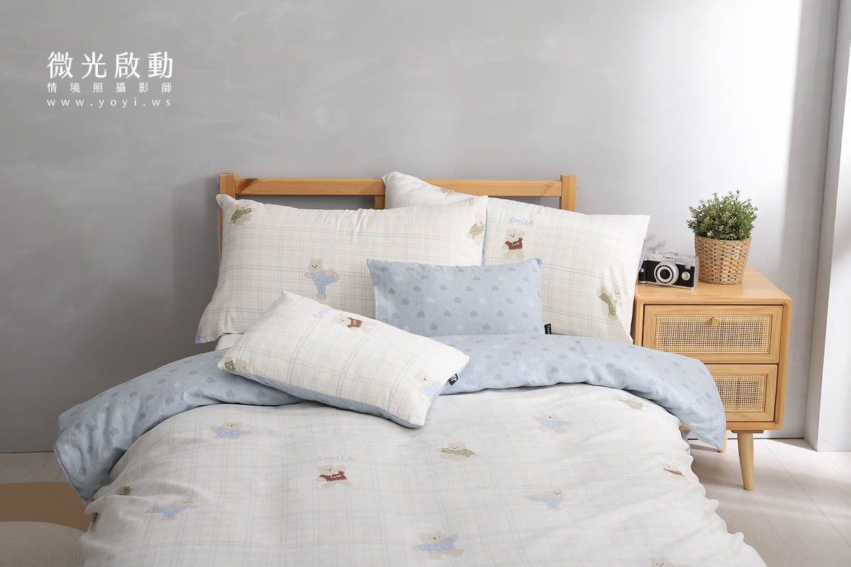 專業商品攝影作品。淺灰色和白色相間的寢具，在陽光照射下呈現清新的視覺效果。適用於寢具攝影、居家商品攝影。