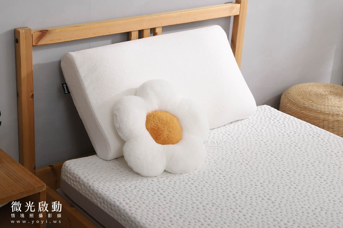 居家寢具攝影服務。淺色床單搭配藍色棉被，與室內的木質家具和綠色植物相呼應，營造自然舒適的氛圍。強調攝影專案、專業攝影。