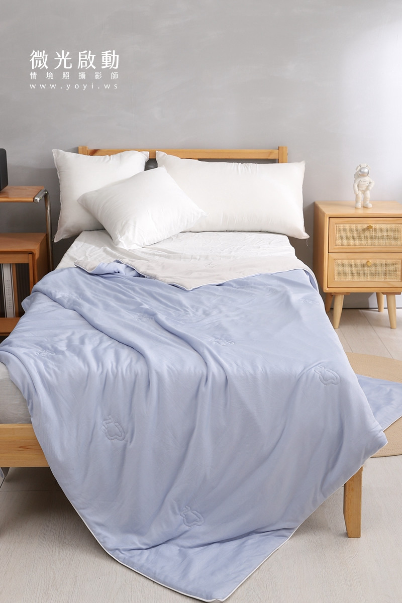 專業商品攝影。特寫鏡頭下，米白色寢具的折疊與細節，展現其高品質的布料。適用於寢具攝影、攝影專案。