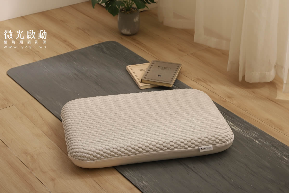 一位女性手持枕頭，臉上露出輕鬆滿足的笑容。