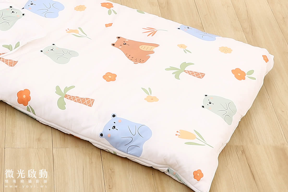 兒童商品攝影：寶寶躺臥在雲朵床墊上，雙手輕舉，展現寢具的寬敞空間與寶寶的自在舒適。