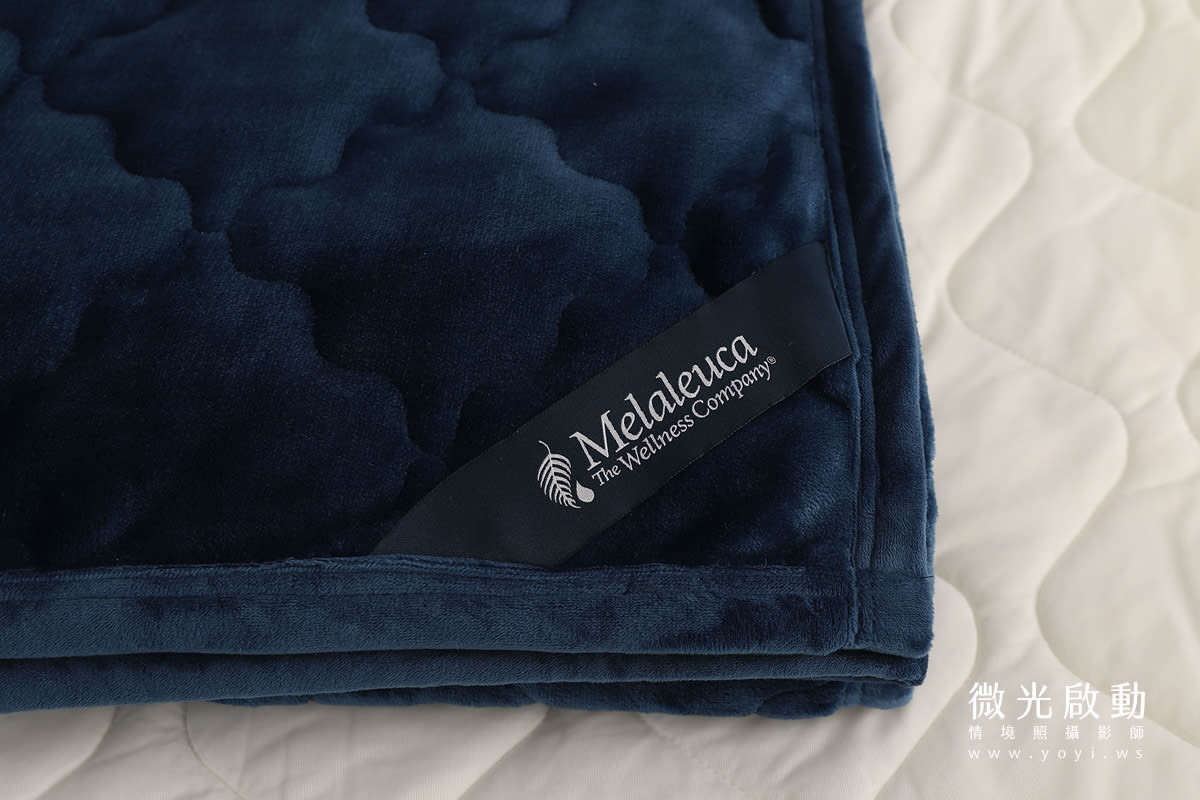 女性模特兒側坐於床上，閱讀書籍，展現舒適自在的居家生活情境