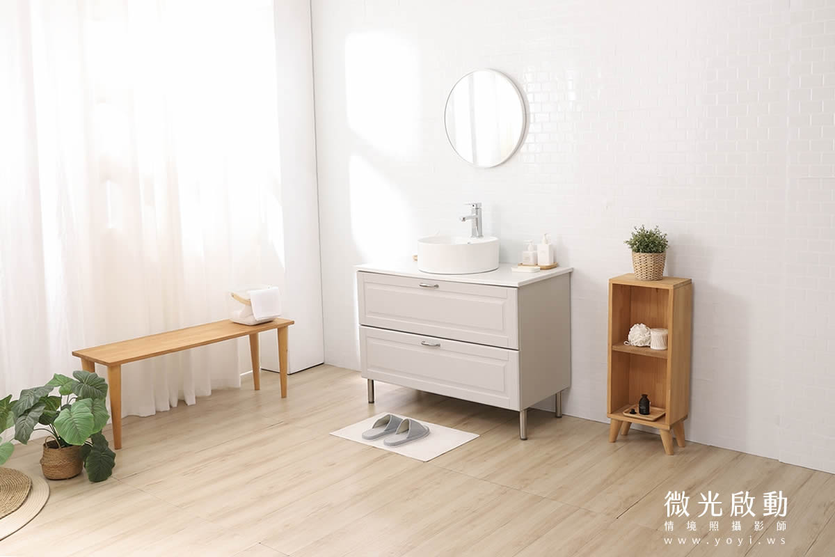 攝影棚浴室景全貌：白色小磁磚背景與淺色木紋地板，配置浴櫃、圓鏡與長木凳，提供保養品商品擺拍場景